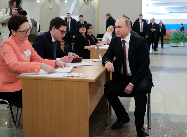 블라디미르 푸틴 러시아 대통령이 18일(현지시간) 모스크바 투표소에서 대선 투표를 하기 전 유권자 명부를 확인하고 있다.(사진=뉴시스)