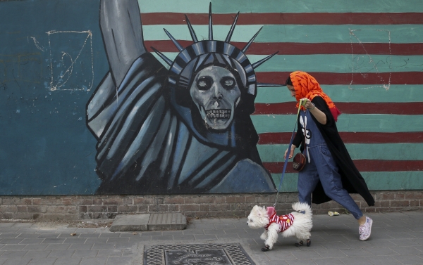 한 이란 여성이 8일 반미 벽화가 그려진 테헤란의 전 미국 대사관 건물 앞을 애완견을 데리고 지나가고 있다. (사진=뉴시스)