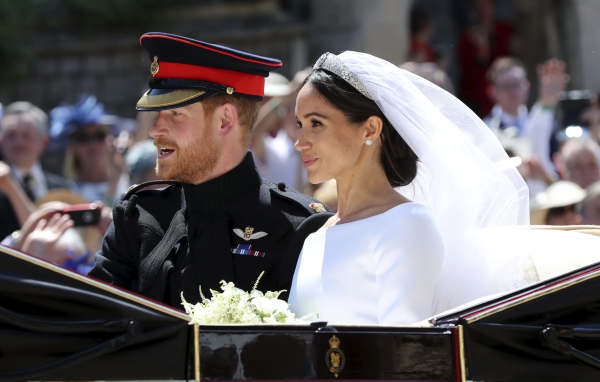 19일(현지시간) 영국 윈저성에 있는 세인트 조지 교회에서 결혼식을 마친 해리 왕자와 메건 마클이 대중들에게 인사하기 위해 지붕없는 마차를 타고 시내를 돌고 있다.(사진 뉴시스)