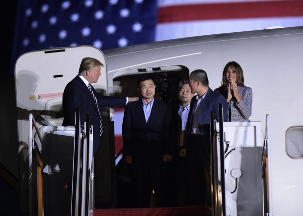 북한에 억류됐다가 석방된 한국계 미국인 3명이 10일 오전(현지시간) 미국 메릴랜드주 앤드루스 공군기지에 도착해 비행기에서 모습을 드러내고 있다. 도널드 트럼프 미 대통령과 영부인 멜라니아 트럼프 여사가 이날 공식 환영식에 참석한 모습.(사진=뉴시스)