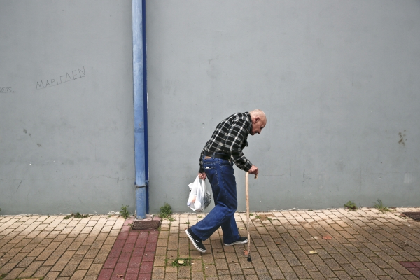 그리스 아테네의 노숙자 음식 제공 시설에서 음식을 받은 한 노인이 걸어가고 있다. 지난 2011년 시작된 경제 위기로 그리스의 실업자, 노숙자는 급속도로 증가하고 있다.(사진=뉴시스)