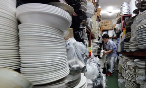 서울 중구 황확시장에서 접시, 주방용품 등을 파는 가게의 상인이 물건을 정리하고 있다.