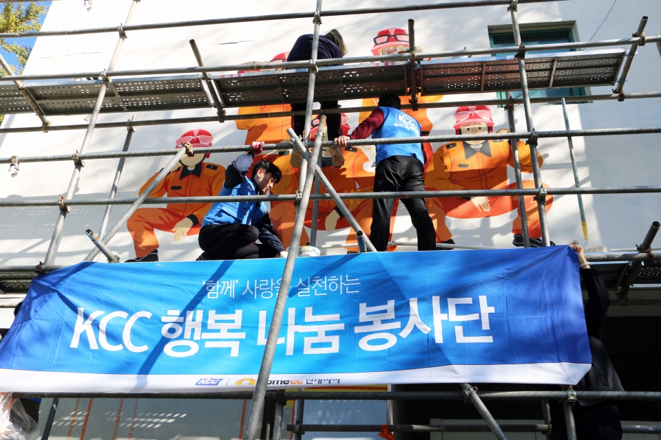 KCC 행복나눔 봉사단이 서초소방서 외벽에 벽화를 그려 넣는 모습.(사진=KCC)