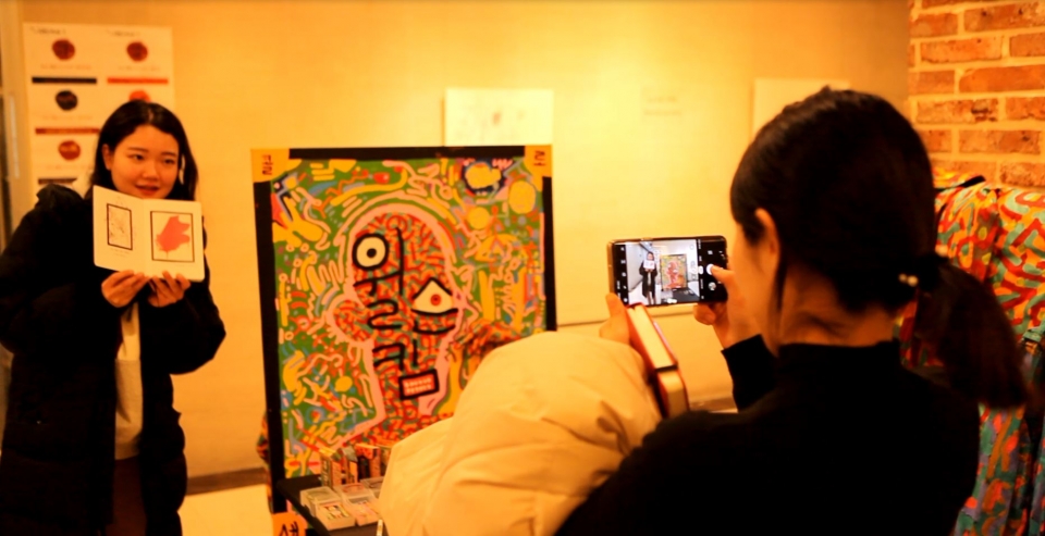 이랜드 직원들이 본사 가산사옥 1층에서 이름으로 그림을 그려주는 초명화 작품에 참여한 뒤 사진을 찍고 있다. (사진=이랜드그룹)