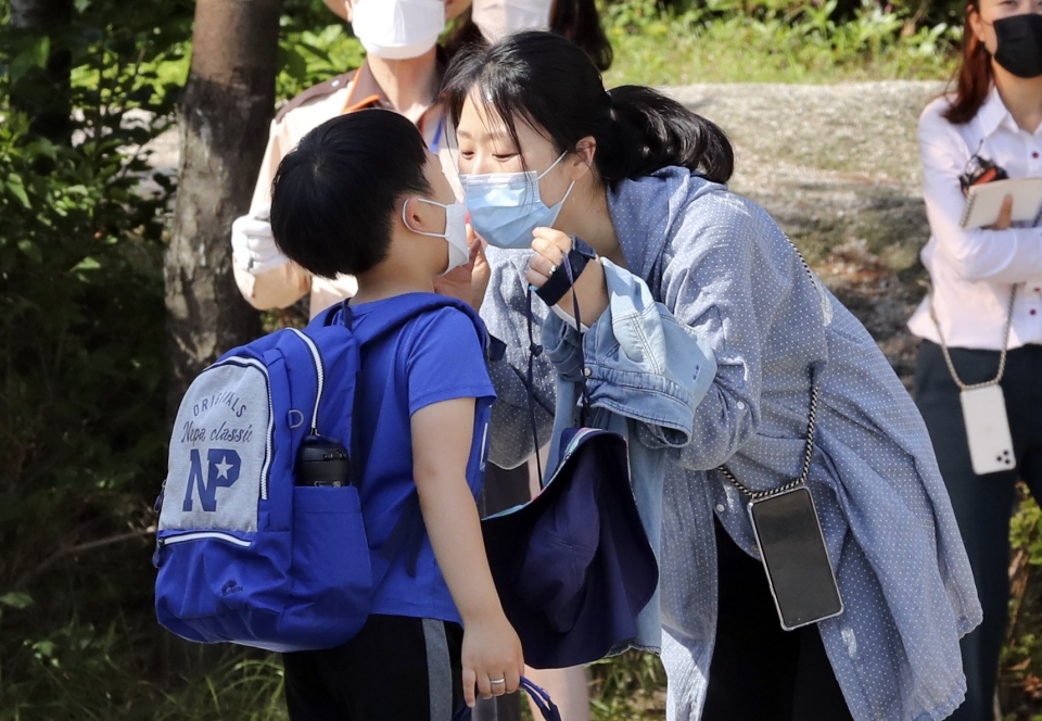 초등학교 1·2학년 학생들이 등교 수업을 시작한 27일 서울 성북구 월곡초등학교에서 학부모가 1학년 자녀를 등교 시키며 마스크 뽀뽀 인사를 하고 있다. (사진=뉴시스)