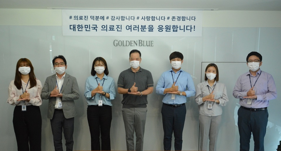 김동욱 골든블루 대표(가운데)와 임직원들이 코로나19와 맞서며 오랜 시간 동안 혼신의 힘을 다하고 있는 의료진을 격려하는 ‘덕분에 챌린지’ 캠페인에 참여했다. (사진=골든블루)
