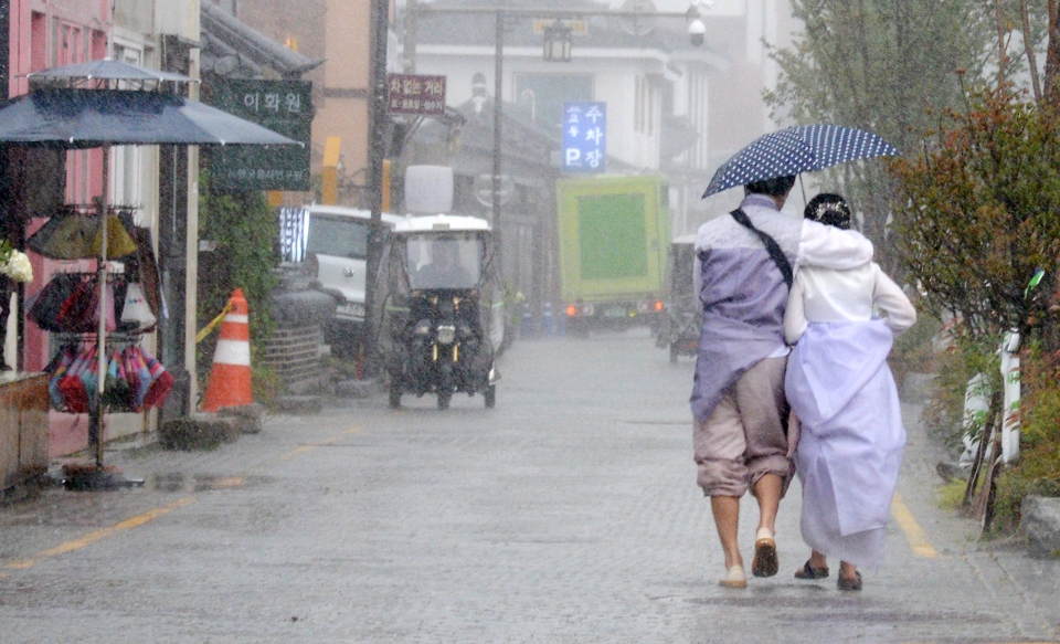 전북 전주시에 갑작스러운 집중호우가 내려, 전주한옥마을 향교 인근에서 관광객들이 우산으로 비를 피하며 발걸음을 옮기고 있다. (사진=뉴시스)
