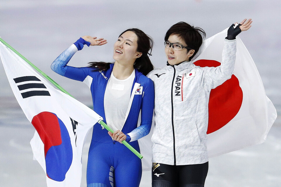 2018 평창동계올림픽 스피드 스케이팅 여자 500m 경기가 끝난 후 은메달을 차지한 한국 이상화(왼쪽)가 금메달을 차지한 일본 고다이라 나오와 함께 태극기와 일장기를 들고 관중들에게 인사하고 있다. (사진=뉴시스)