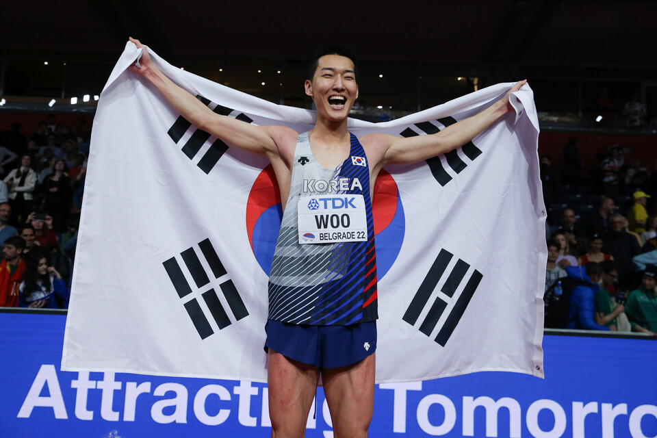 우상혁이 20일(현지시간) 세르비아 베오그라드의 스타크 아레나에서 열린 2022 세계실내육상선수권대회 남자 높이뛰기 결선에서 1위를 차지, 태극기를 몸에 두르고 기뻐하고 있다. 우상혁은 2m34를 넘어 금메달을 목에 걸며 한국 선수 최초로 세계실내육상선수권 메달리스트로 등극했다. (사진=신화/뉴시스)