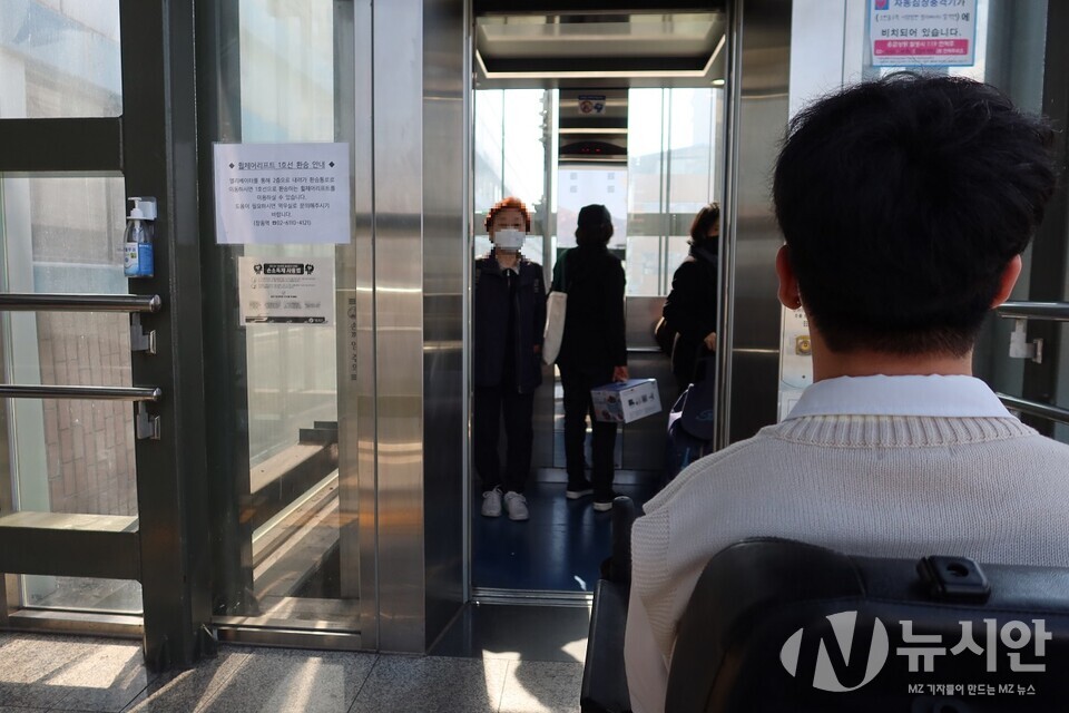 엘레베이터 탑승을 기다리는 종욱씨. 전동휠체어로 이동하는 그를 제치고 종종걸음으로 엘레베이터에 앞서 올라타는 어른들을 바라보고 있다. (사진=김용태 기자)