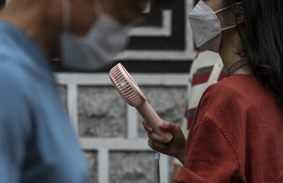 서울 종로구에서 한 시민이 손 선풍기로 더위를 식히고 있다. (사진=뉴시스)