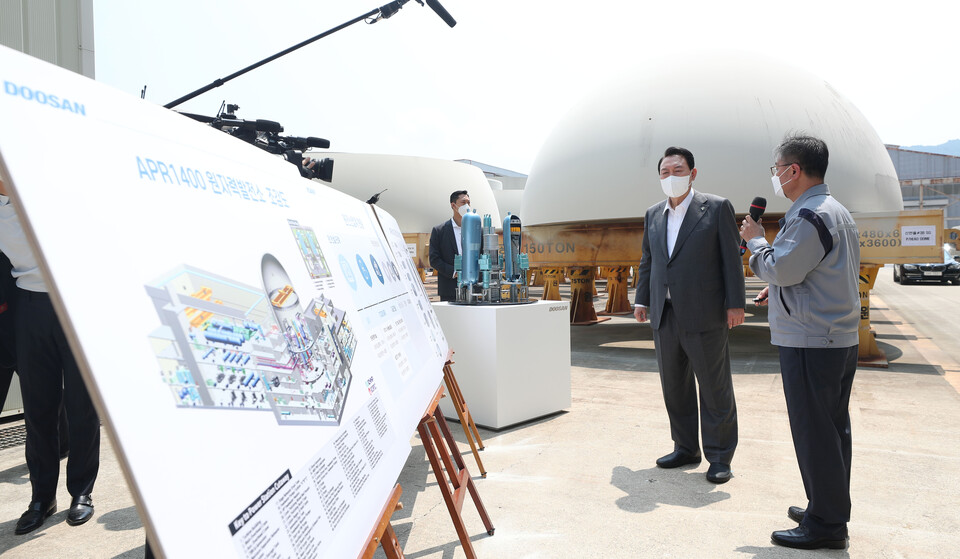 윤석열 대통령이 22일 경남 창원 두산에너빌리티 원자력 공장을 방문해 APR1400 원자력발전소 조감도를 살펴보고 있다. [사진=뉴시스]