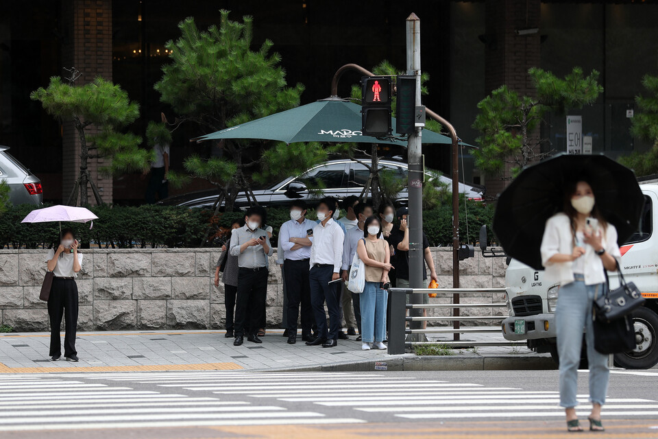 소나기가 내린 22일 오후 서울 마포구 가든호텔 앞에서 우산이 없는 시민들이 차양막 밑에 모여 있다. (사진=뉴시스)