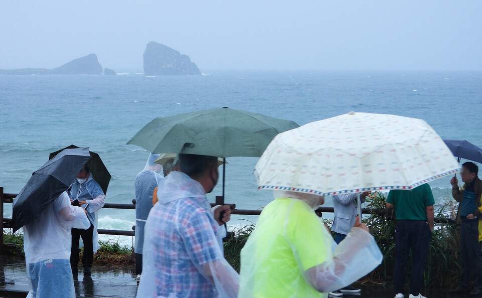지난 2일 오후 제주 서귀포시 대정읍 송악산에 우산을 쓴 관광객들이 걸어가고 있다. [사진=뉴시스]