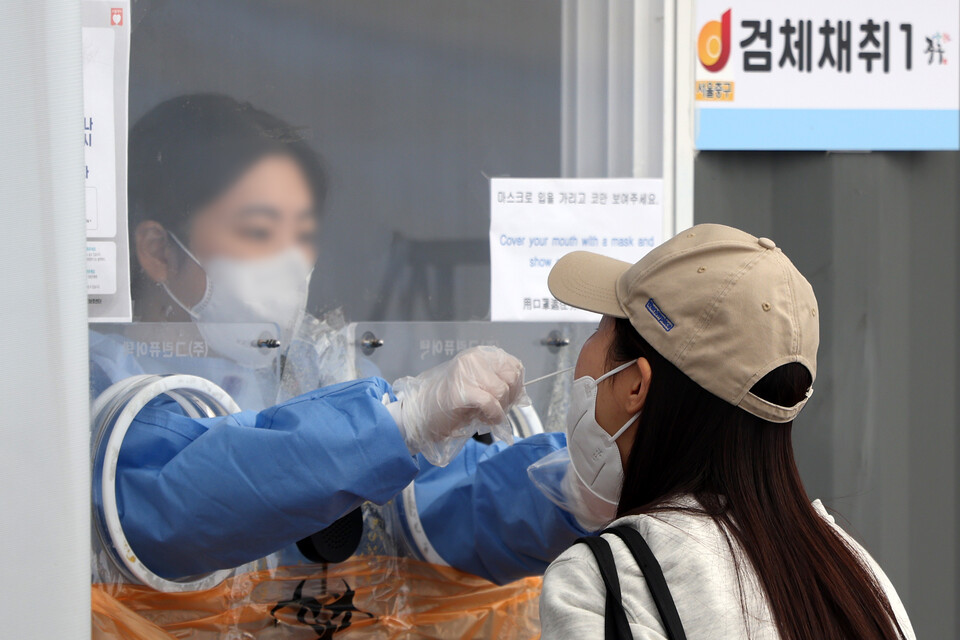 지난 7일 오후 서울 중구 서울역광장에 마련된 임시선별검사소에서 의료진이 검체를 채취하고 있다. [사진=뉴시스]