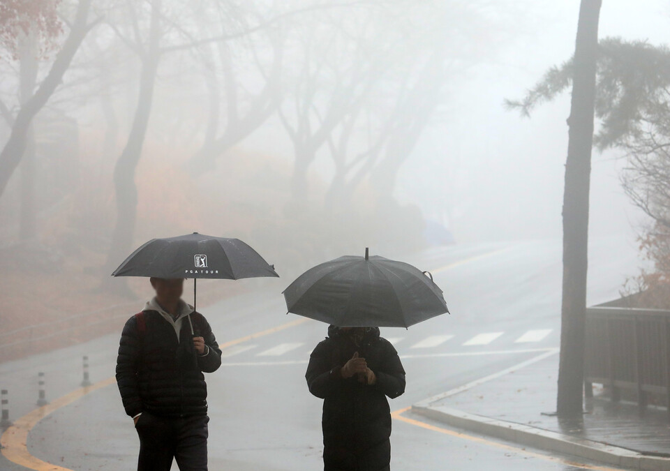 겨울비가 내리는 지난 14일 오후 서울 중구 남산에서 시민들이 우산을 쓰고 둘레길을 걷고 있다. [사진=뉴시스]