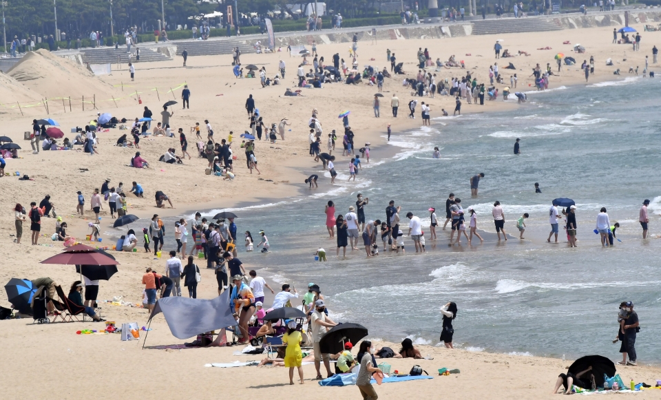 고물가가 지속되면서 10명 중 7명이 여름휴가를 포기하거나 계획을 정하지 않고 있는 것으로 조사됐다. 해운대해수욕장을 찾은 시민과 관광객들이 물놀이를 즐기고 있다. [사진=뉴시스]