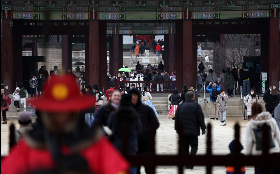 지난 14일 서울 종로구 경복궁을 찾은 외국인 관광객들이 궂은 날씨에도 기념사진을 찍으며 한국 관광을 즐기고 있다. [사진=뉴시스]