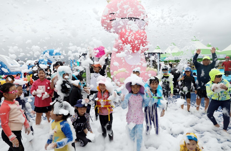 부산 남구 용호별빛공원에서 열린 '2023년 남구 물놀이 축제'를 찾은 어린이들이 인체에 무해한 거품 눈을 맞고 있다. [사진=뉴시스DB]