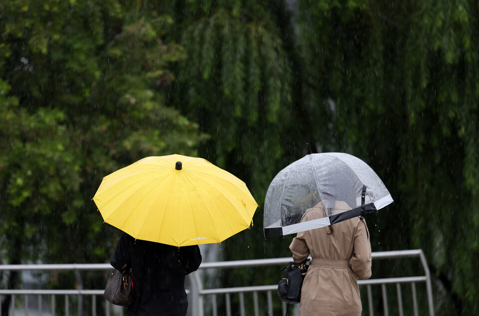 가을비가 내린 지난달 서울 서초구 세빛섬 인근에서 시민들이 우산을 쓰고 발걸음을 재촉하고 있다. [사진=뉴시스]