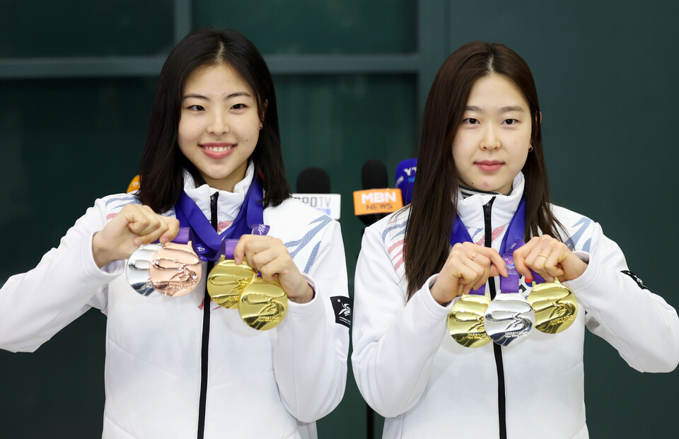 2025 하얼빈 동계아시안게임에 출전해 메달을 획득한 스피드스케이팅 이나현(금2·은1·동1, 왼쪽), 김민선(금2·은1)이  5월 12일 오후 인천국제공항 제1터미널을 통해 귀국해 메달을 들어보이고 있다. [사진=뉴시스]