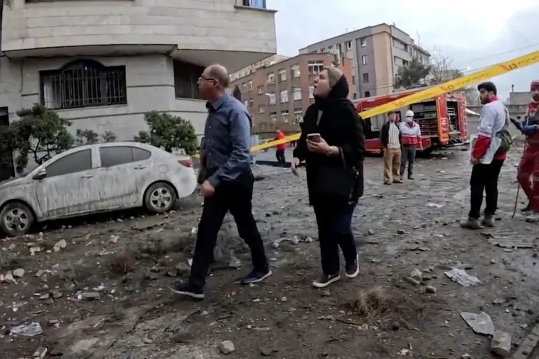 공습이 보고된 테헤란의 한 통제 구역에서 이란 적신월사 대원들이 수습 작업을 벌이는 가운데, 시민들이 피해 상황을 살펴보고 있다. [사진 제공=이란 적신월사/로이터 연합뉴스]